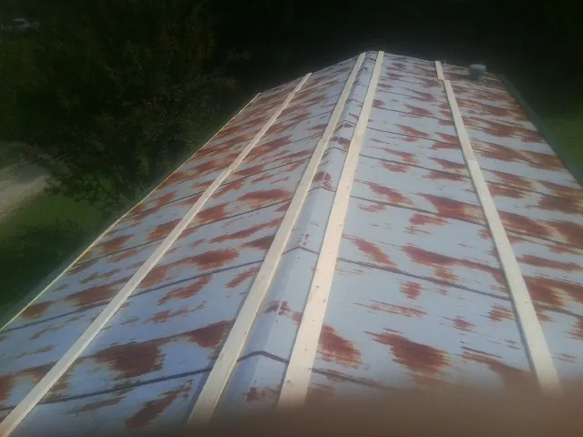 Rusted metal roof panels with new wood purlins before replacement — Storm Damage Roof Repair in Glenn Dale by Roofing Brothers