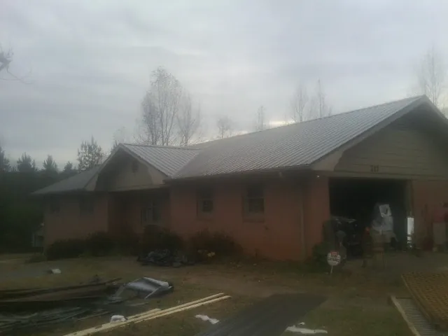 Gray metal roof on a stucco house with an attached garage in Glenn Dale