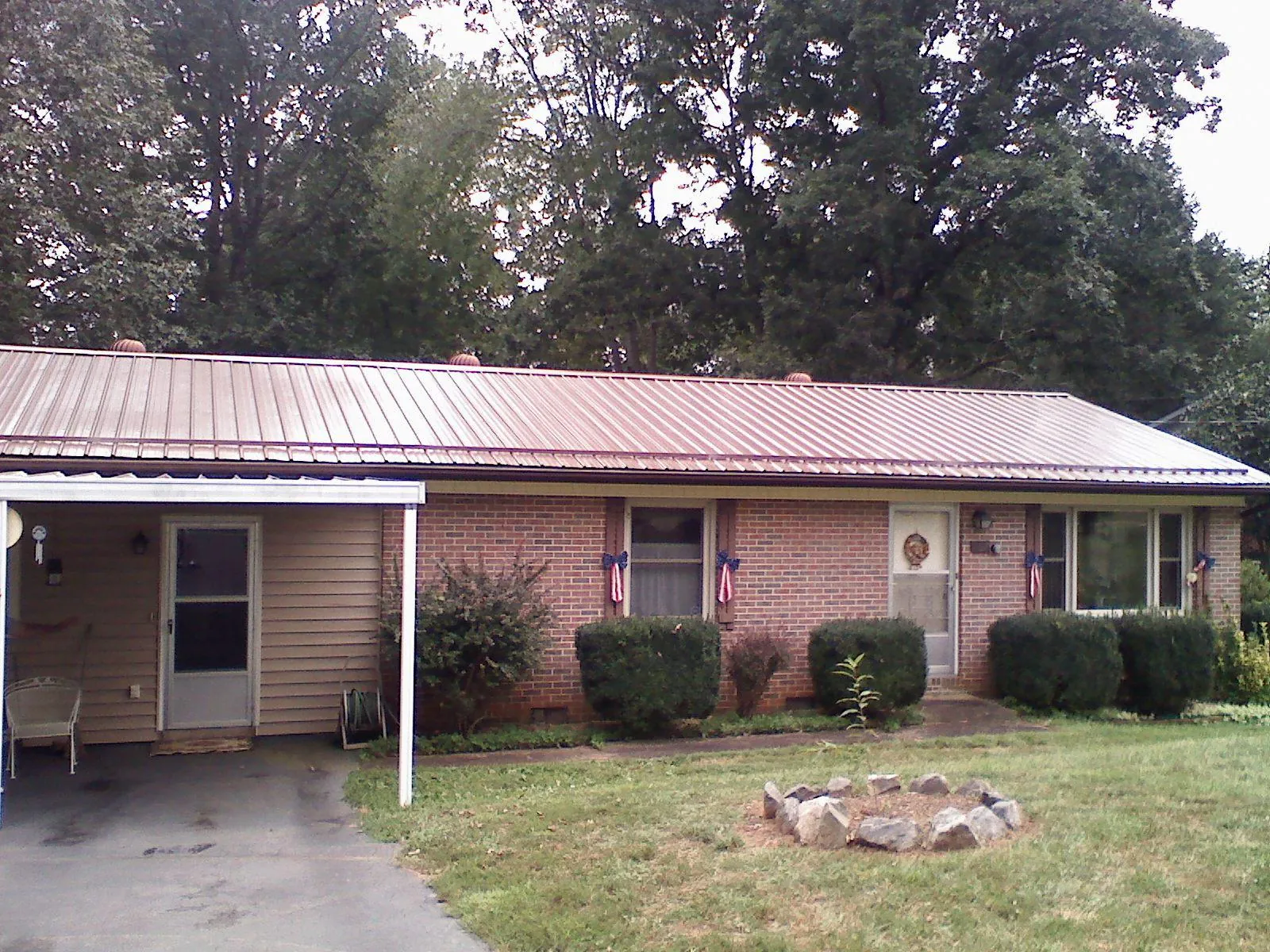 Bronze metal roof and carport on a brick ranch home — Roof Repair work by our crew in Glenn Dale